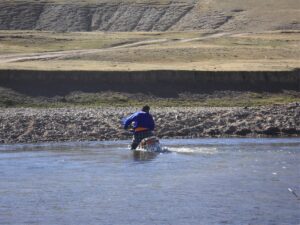 バイクで川を渡るモンゴル人